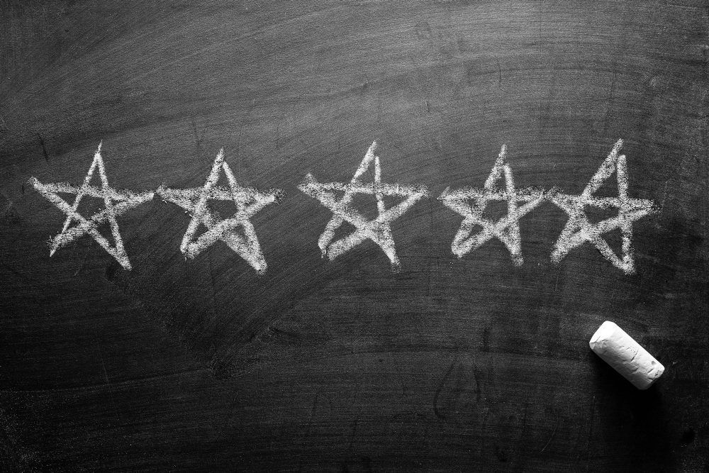 Line of five stars hand drawn on a blackboard